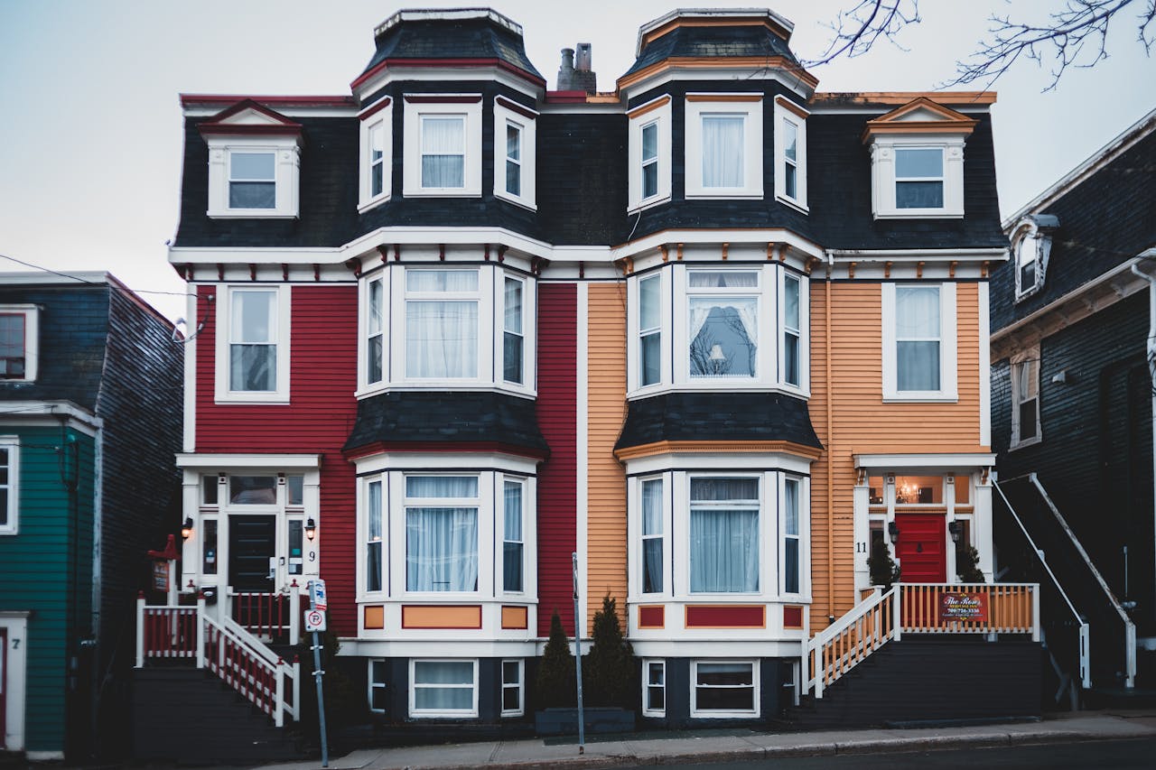Vibrant Victorian-style house facade with red and yellow exterior in an urban setting.